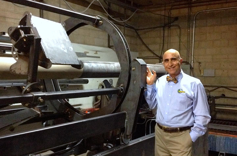 Ehsani stands next to a prototype of the machine that allows people to manufacture pipes on a truck or boat. Source: QuakeWrap